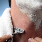 Man shaving neck with razor