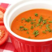 Bowl of cream of tomato soup garnished with chives.