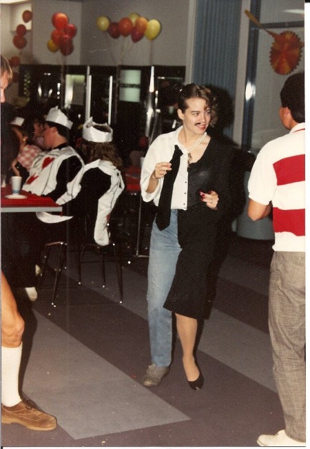 A halloween costume where the right side is a man in a white shirt, jeans and a tie, and the left is a woman in a black dress with heels.