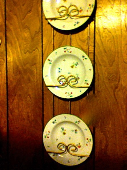 3 China plates hanging on wall in plate rack