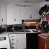 Pots, pans and lidshanging on the pegboard in kitchen.