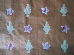 Star stenciled onto brown paper next to trees