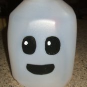 Finished milk jug ghost. Black eyes and black mouth painted on white milk jug.