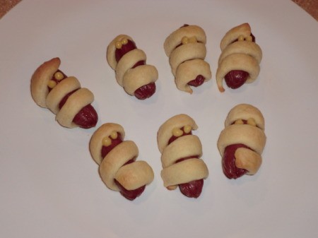 Croissant wrapped sausages as a Halloween appetizer.