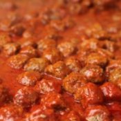 Meatballs cooking in sauce.