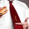 Man Holding Burger with Mustard Stain on his Tie