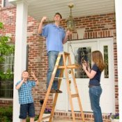 Family Working on Hanging Outdoor Christmas Lights