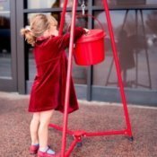 Little girl giving to Salvation Army.