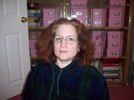 Woman sitting in front of pink, labelled photo boxes