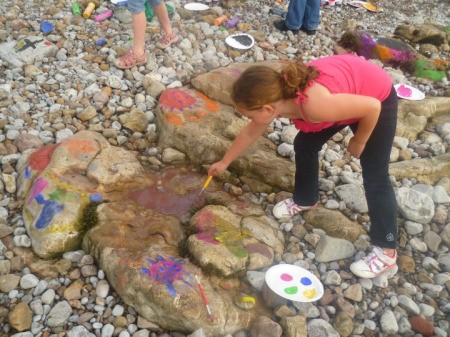 Girl Painting Rocks on the Beach