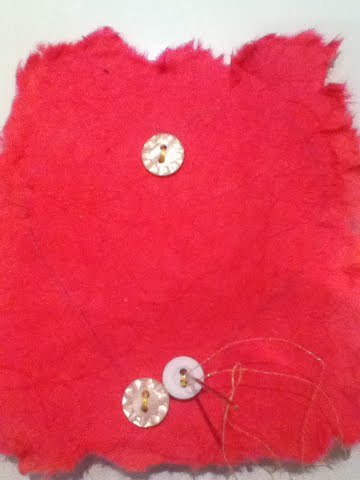 Button Love Christmas Present - white buttons being sewn onto red material