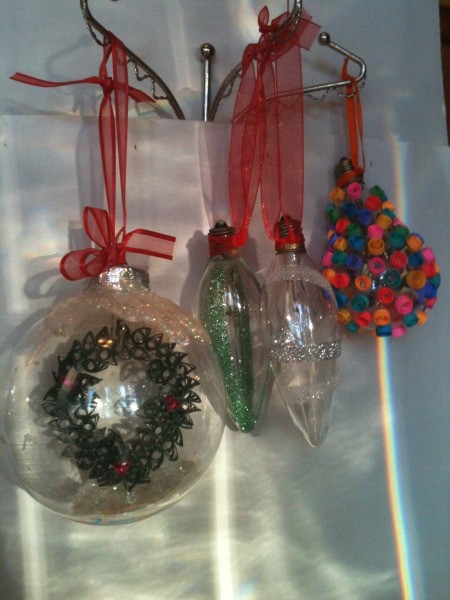 Three clear Christmas ornaments with decorative inclusions.