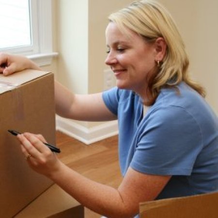 Tips for Organizing Your Move, A woman labeling moving boxes.