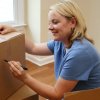 Tips for Organizing Your Move, A woman labeling moving boxes.