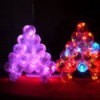 Photo of a lit Christmas tree made with baby food jars.