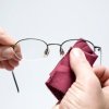 Cleaning eyeglasses with a cloth.
