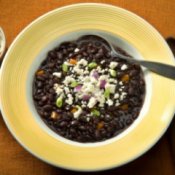 A bowl of hearty black bean soup with a sprinkling of cheese.