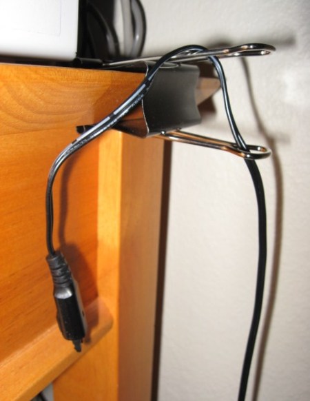 Black Paper Clip attached to edge of desk for cord