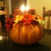 Styrofoam pumpkin centerpiece with candle lit.