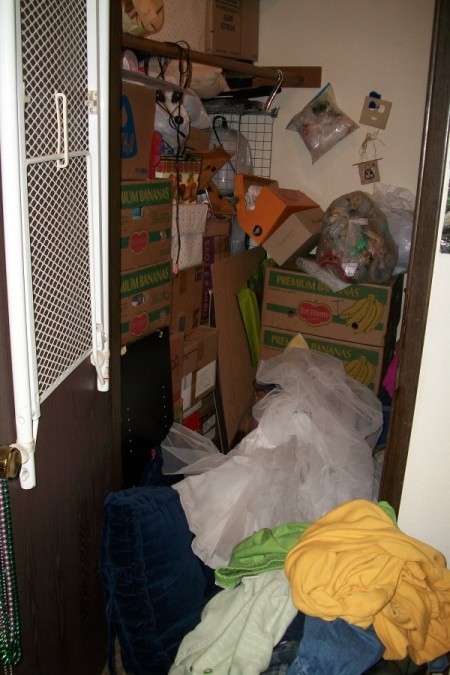 Closet before reorganizing, stacks of boxes and bags piled all over