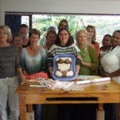 Ladies sewing group with a torso cake in bra and panties.