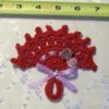 A small red crocheted fan.