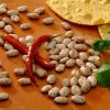 Scattering of dried pinto beans with red peppers and cilantro. Cooking Dried Beans