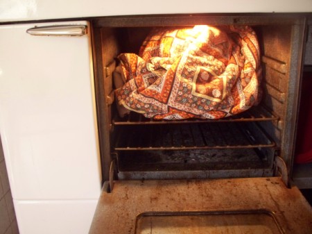 Towel covered bowl of yogurt in oven