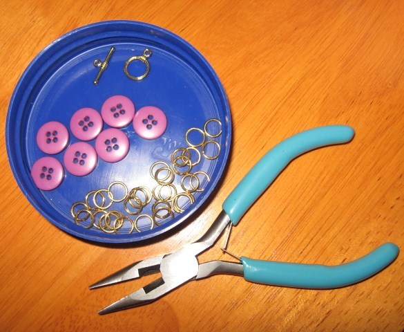 Buttons, jump rings, toggle clasp, and needle nose pliers.