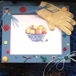 Finished framed print with embellishments, such a a glove, ribbons, buttons, and tiny trowel, etc.