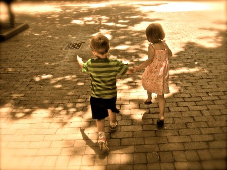 Little boy and girl skipping in walking mall