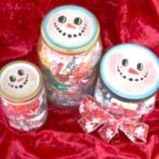 Jar lids decorated to look like snowmen.