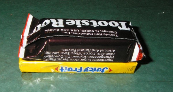 Placing Tootsie Roll on gum package.