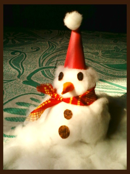 Finished snowman sitting on cotton snow.