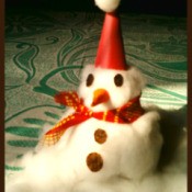 Finished snowman sitting on cotton snow.