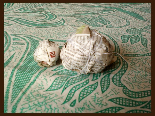 Two newspaper balls tied with string.