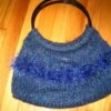 A purse that has been knitted from blue yarn.