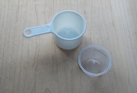 Measuring cup next to empty apple sauce container.