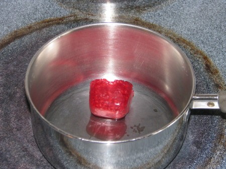 Pot with a frozen berry cube inside.