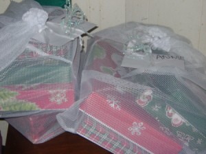 Pipe cleaner bows on mesh bag of gifts.