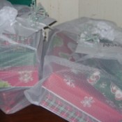 Pipe cleaner bows on mesh bag of gifts.