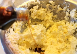 Adding vanilla extract to creamed butter mixture.