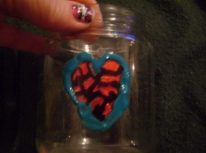 A jar painted with a heart for a stained glass effect.