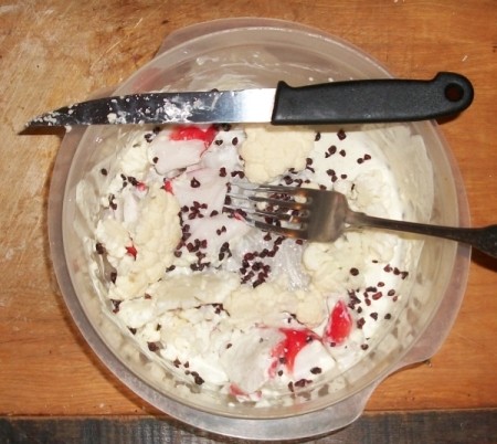 A bowl with surimi, cauliflower and dehydrated cranberries.