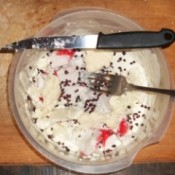 A bowl with surimi, cauliflower and dehydrated cranberries.