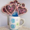 A bouquet of heart shaped cookies in a coffee cup, for Valentine's Day.