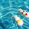 Saving Money on Winter Vacations, Snowman and Snowwoman Enjoying the Pool and Warm Sun Together