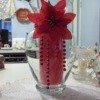 A Christmas candle holder with a red poinsettia.