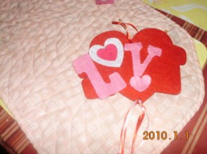 Gluing letters and hearts to main felt heart shape.