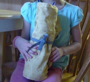 Pipe Cleaner Play Case - Child holding rolled mat storage case.